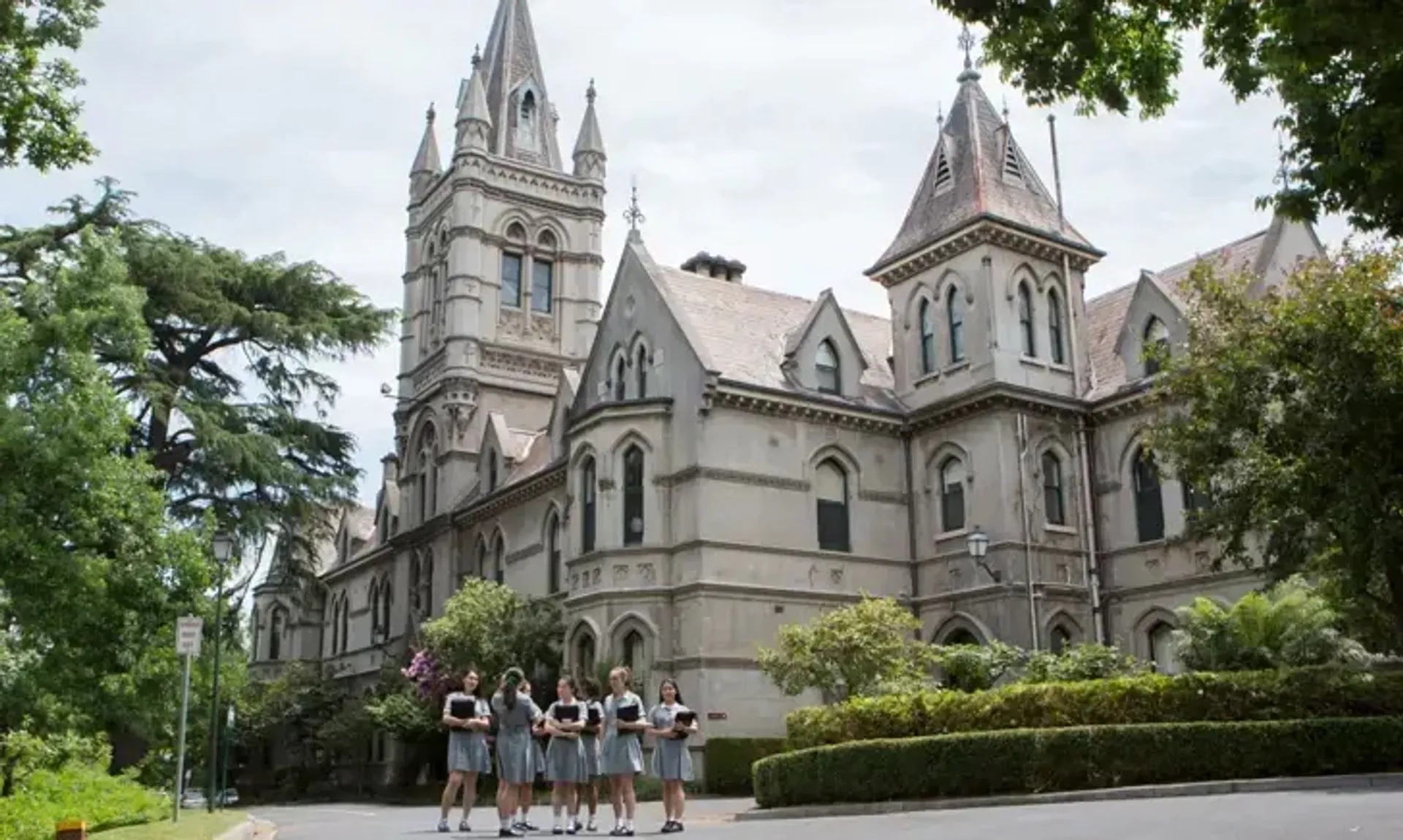 Davanti alla maestosa cattedrale, un gruppo di persone siede su un prato all'interno del campus del Methodist Ladies' College.