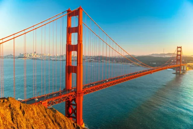 Vista aerea del Golden Gate Bridge al tramonto con lo skyline di San Francisco sullo sfondo