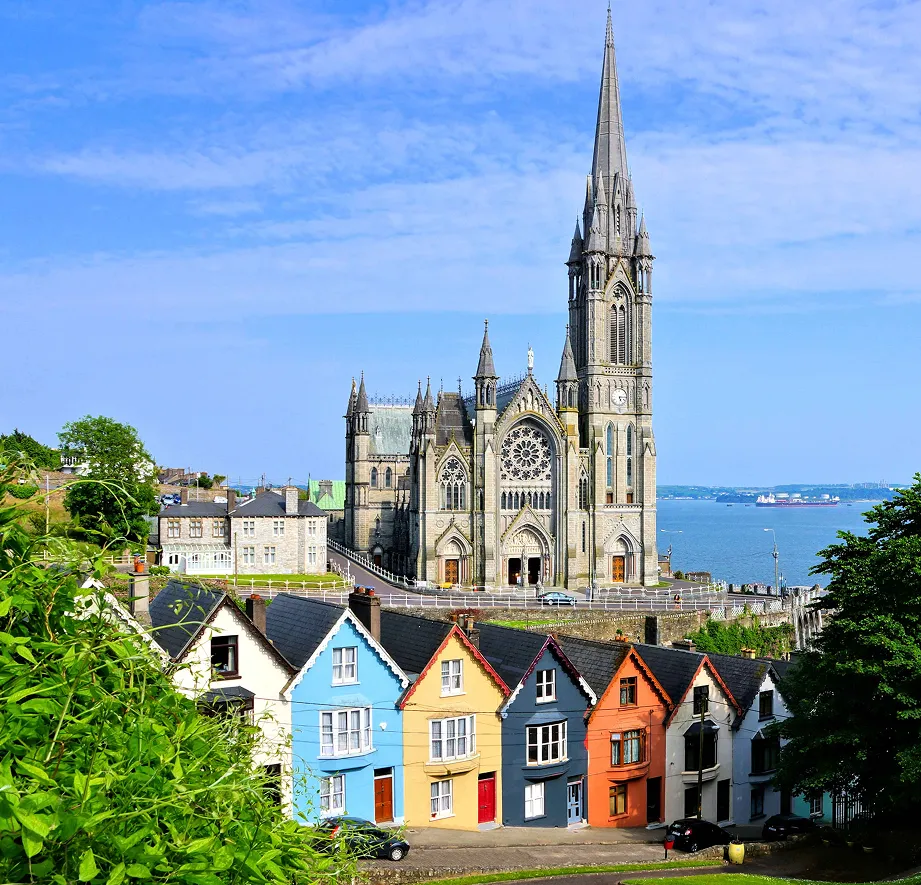 Catedral neogótica de Cobh sobre una hilera de casas de colores frente al mar