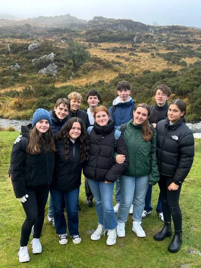Grupo de alumnos posando en un paisaje irlandés de colinas cubiertas de niebla