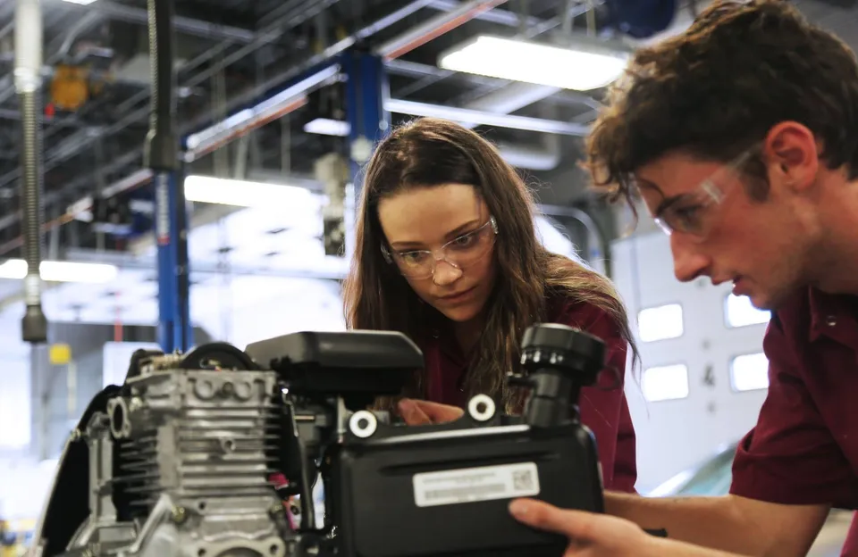 Una donna e un uomo esaminano un dispositivo tecnico in un laboratorio nel Poudre School District.