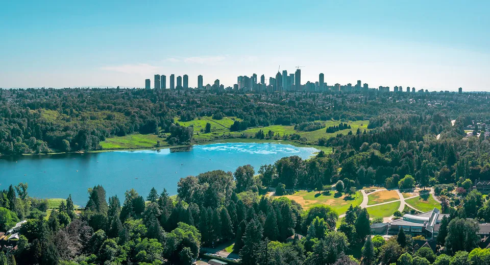 Un panorama paesaggistico boscoso con un lago e grattacieli in lontananza vicino alla Byrne Creek School.