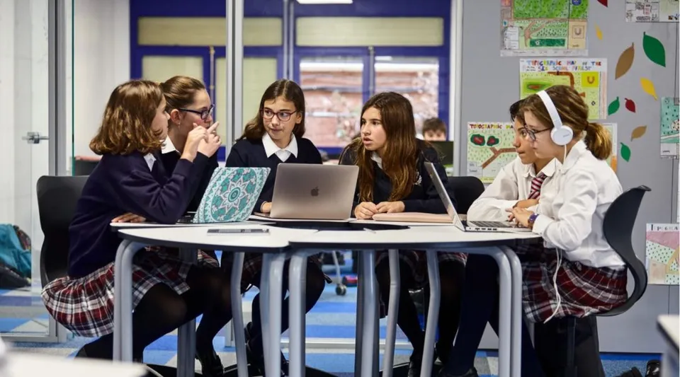 Studenti della SEK International School El Castillo lavorano insieme a un laptop in classe.