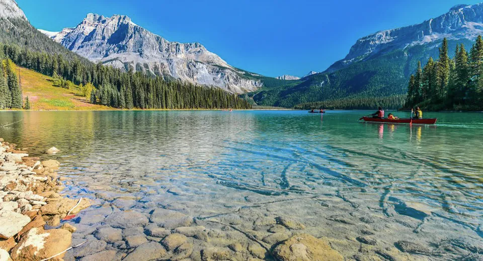 Un lago di montagna limpido nella regione della Aldergrove Community Secondary School con persone in canoa.