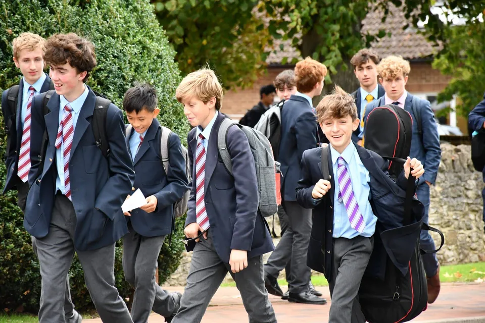 Un gruppo di studenti della Abingdon School cammina insieme lungo un sentiero circondato da piante verdi.