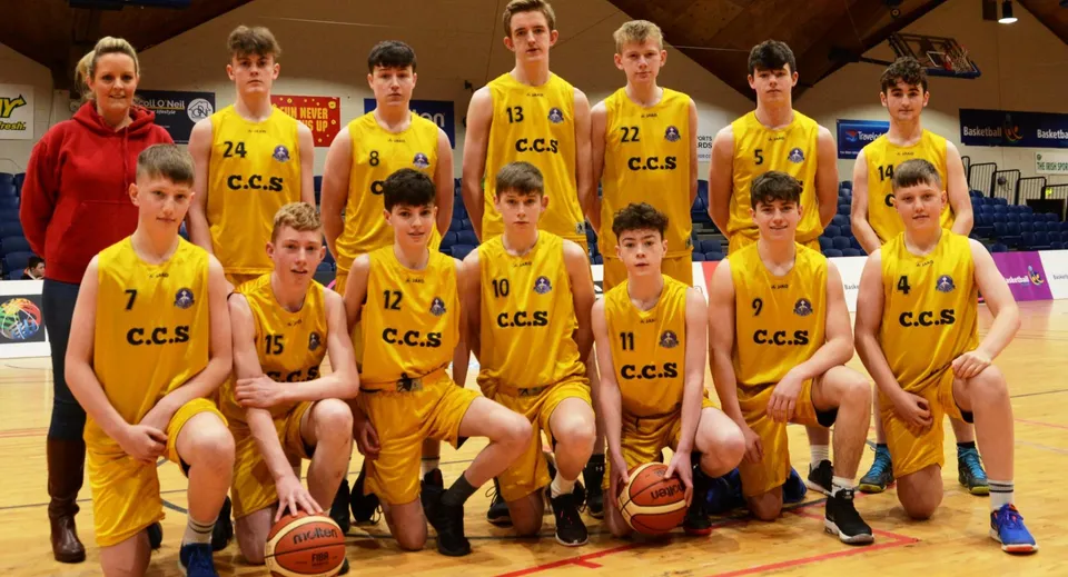Un gruppo di giovani giocatori di basket della Carrick on Shannon Community School in posa insieme sul campo da basket.
