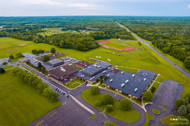 Paesaggio con campo sportivo ed edifici nell'area della Red Creek High School in una zona rurale.
