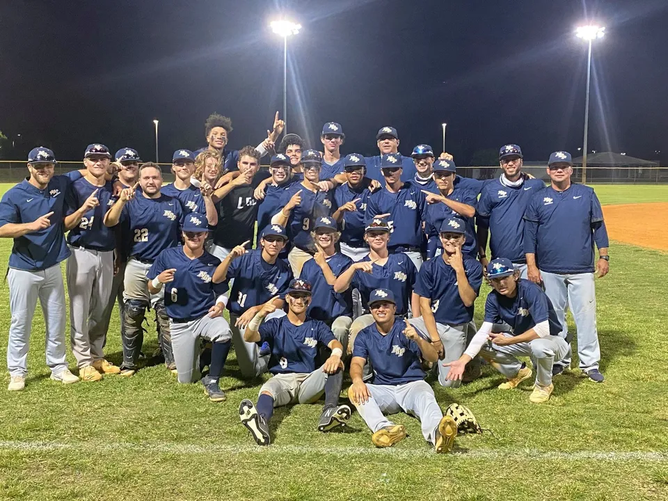 Studenti della North Broward Preparatory School festeggiano la vittoria di notte sul campo da baseball.