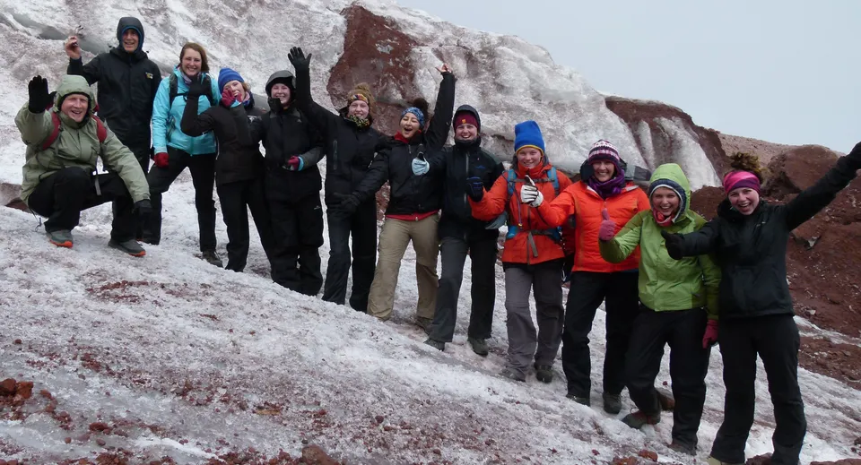 Studenti del Coláiste an Chreagáin si trovano insieme in un paesaggio montano invernale coperto di neve.