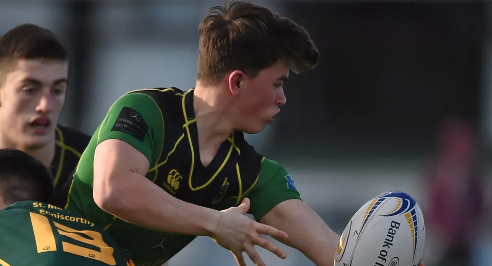 Uno studente del St. Conleths College tiene un pallone da rugby sul campo sportivo.