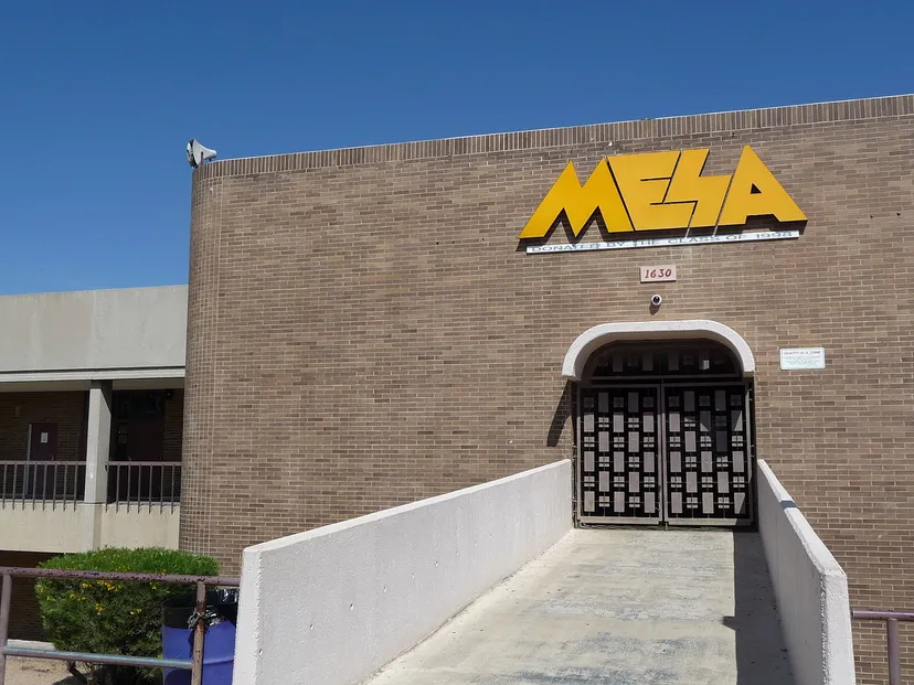 L'edificio in mattoni con un'insegna gialla MESA mostra la facciata della Mesa High School sotto un cielo limpido.