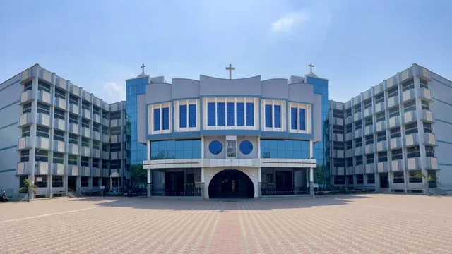 L'edificio principale della St. Michael's School con facciata in vetro blu e un ampio cortile pavimentato.