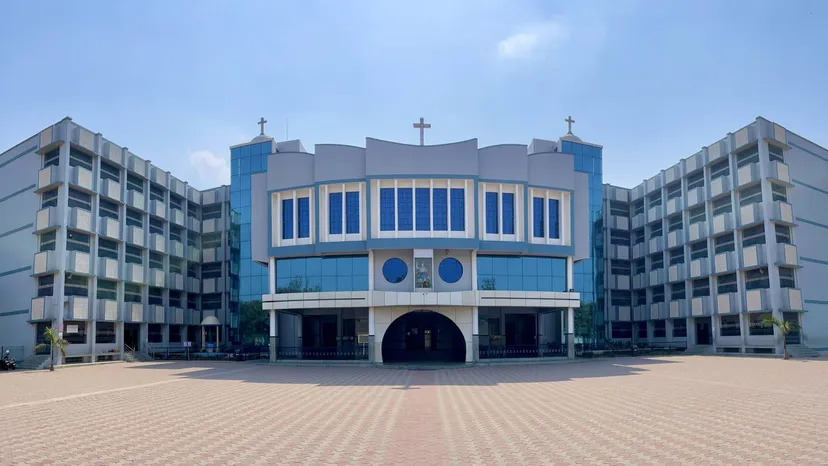 L'edificio principale della St. Michael's School con facciata in vetro blu e un ampio cortile pavimentato.