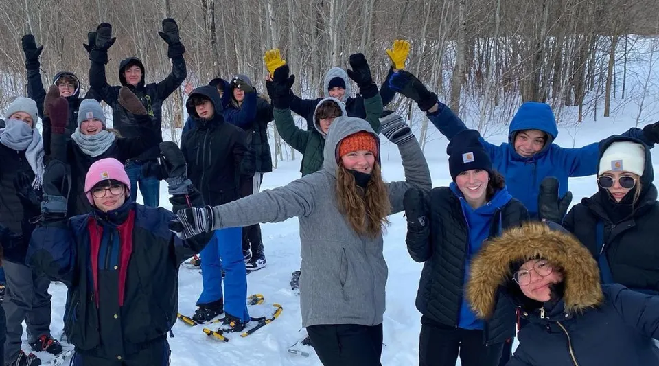 Studenti della Glengarry District High School festeggiano insieme in un bosco innevato.