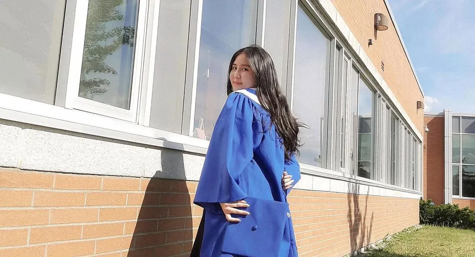 Una studentessa si trova davanti a un edificio in mattoni nel campus della Markham District High School.