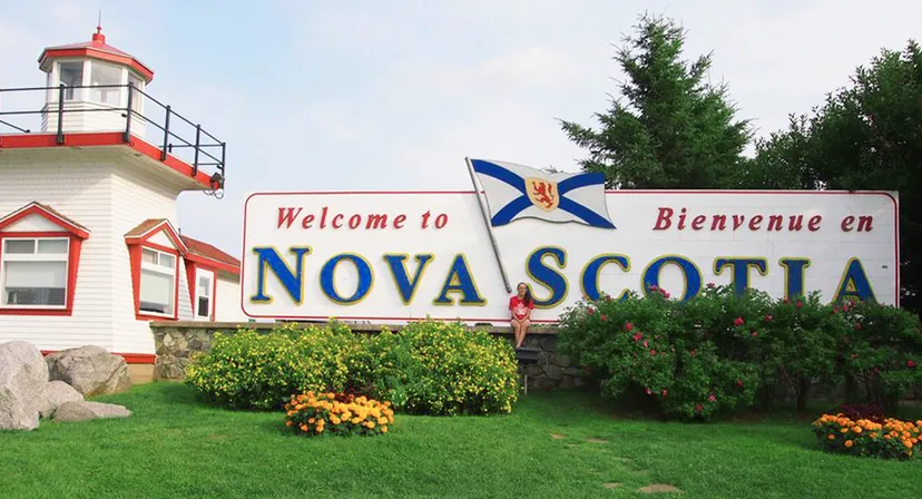 Il cartello di benvenuto della Nova Scotia con struttura a faro e bandiera canadese sul campus del Nova Scotia French Program.