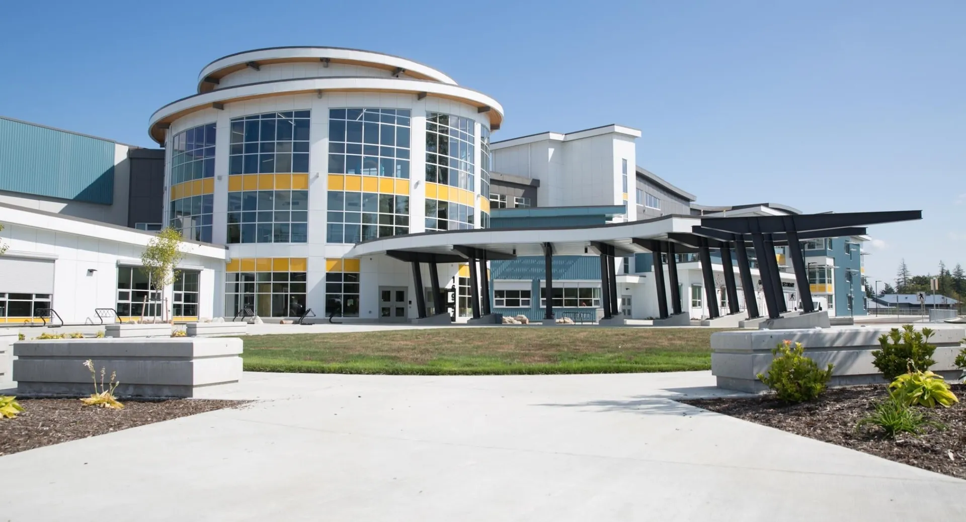 L'edificio moderno a più piani con facciata vetrata della Grandview Heights Secondary School è circondato da un'area esterna ben curata.