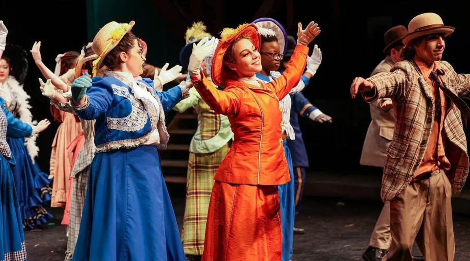 Un gruppo di ballerini in costumi colorati si esibisce sul palco di The Stony Brook School.