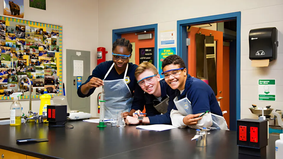 Un gruppo di studenti e studentesse si raccoglie nel laboratorio della St. Michael Catholic Secondary School attorno a un tavolo con strumenti scientifici.
