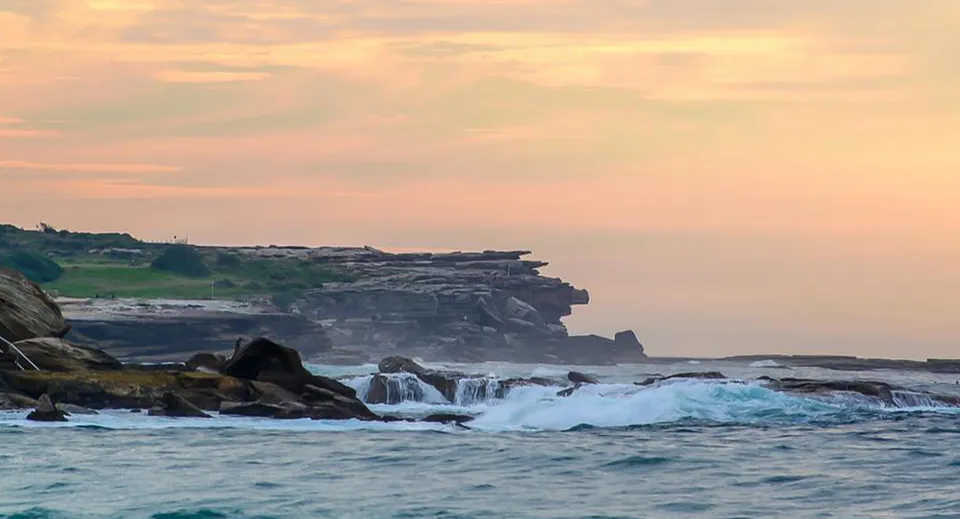 Un paesaggio costiero spettacolare con scogliere e tramonto, vicino alla Bribie Island State High School.
