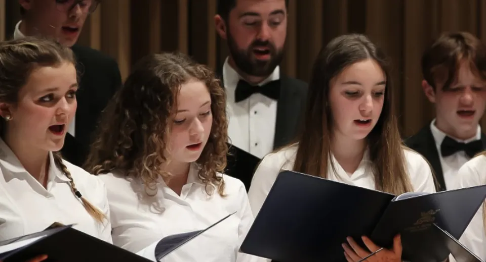 Studenti della King's Bruton si esibiscono insieme in un'esibizione canora su un palco.