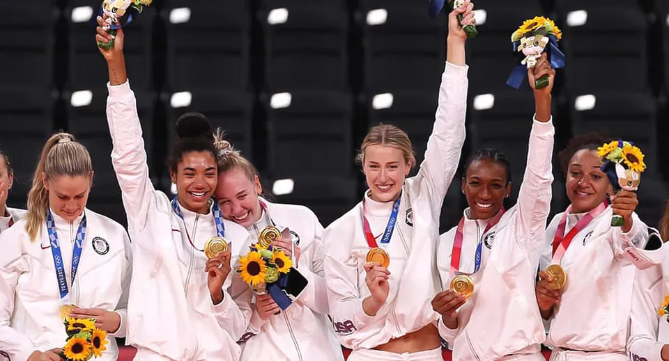 Atlete della Mannahouse Christian Academy festeggiano con medaglie d'oro e girasoli su uno sfondo scuro.