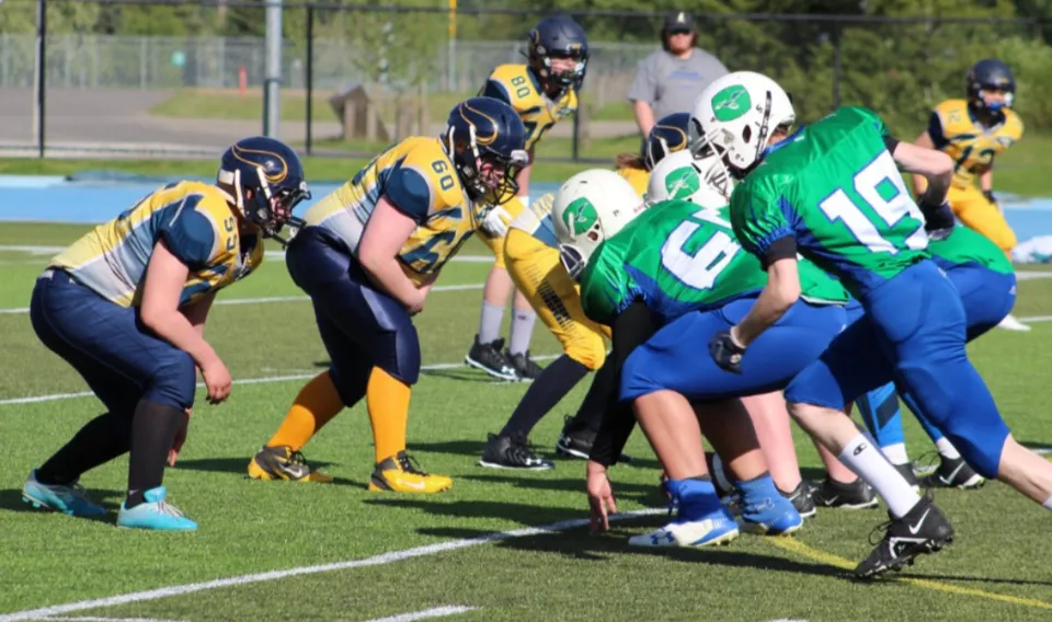 Un gruppo di giocatori di football disputa una partita sul campo sportivo della Shas Ti Kelly Road Secondary School.