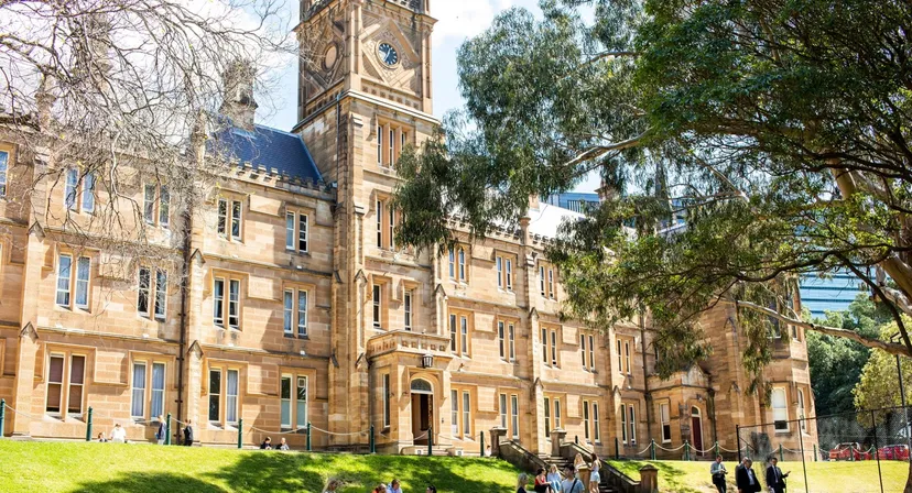 L'edificio storico del St. Andrew’s College con una torre dell'orologio e un prato in primo piano.