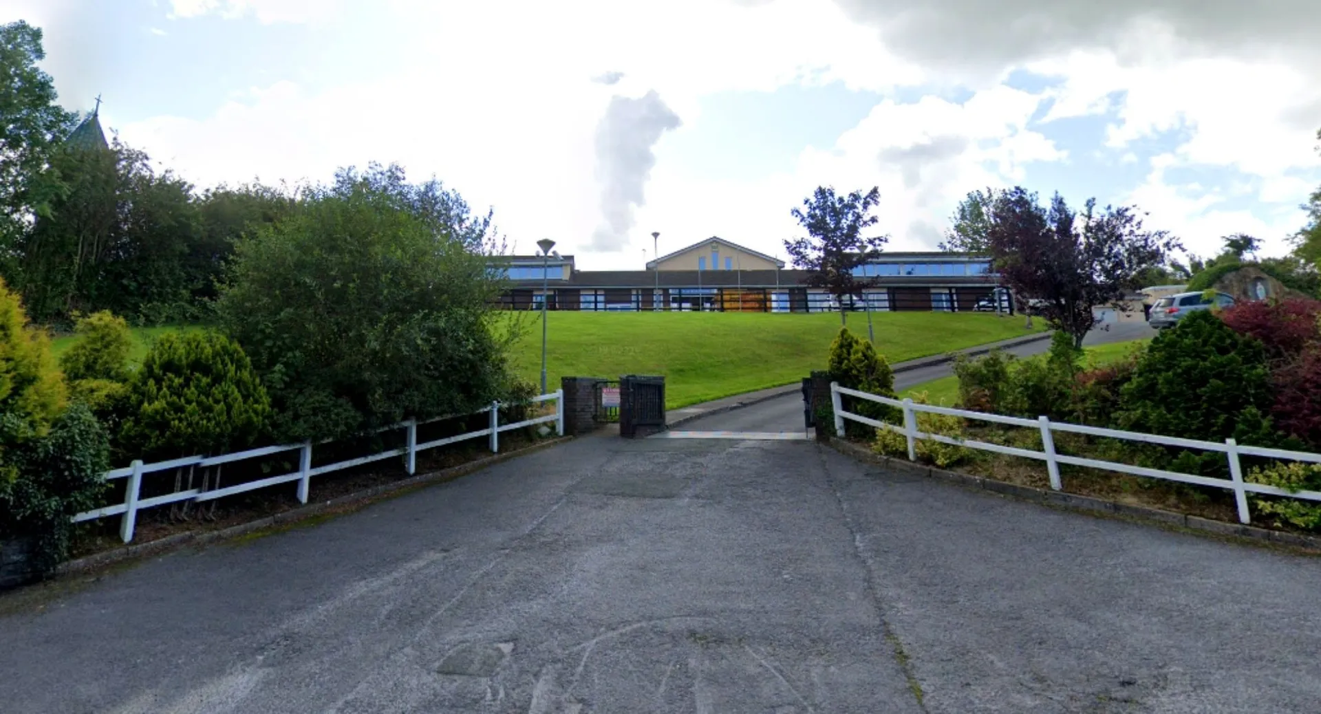 Il viale d'accesso della Scoil Mhuire Kanturk conduce oltre un prato verde verso l'edificio scolastico.