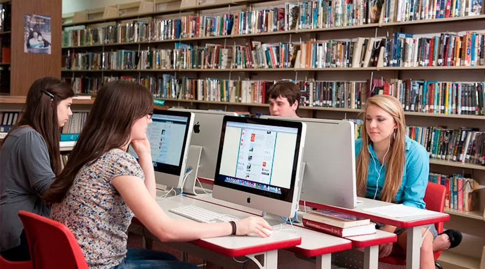 Un gruppo di giovani studentesse lavora al computer nella biblioteca della Stuart Hall School.
