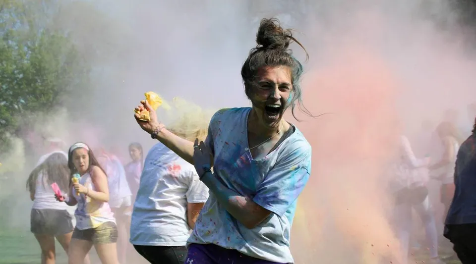 Una persona nel campus della Shattuck-St. Mary's School è coperta di polvere colorata e circondata da altre persone.