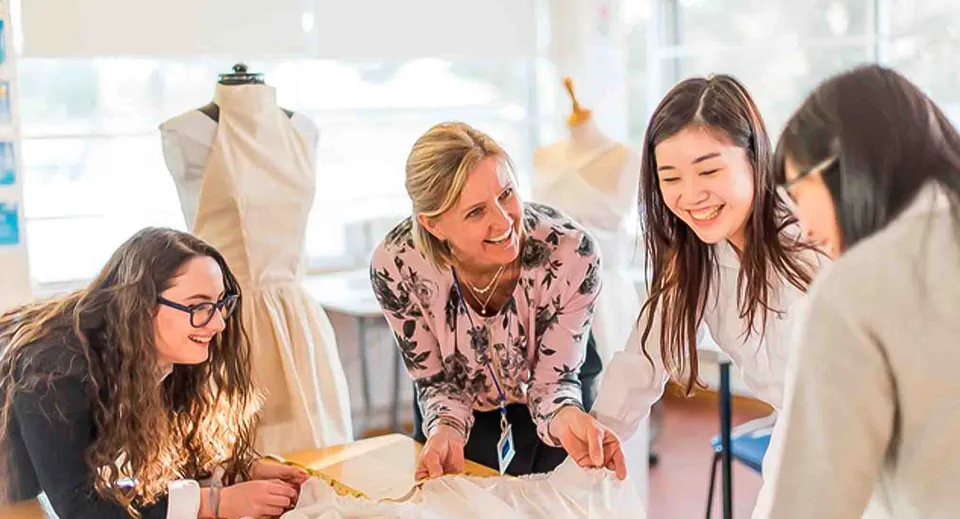 Studentesse della St. Mary's School lavorano insieme in uno studio di Fashion Design con macchine da cucire.