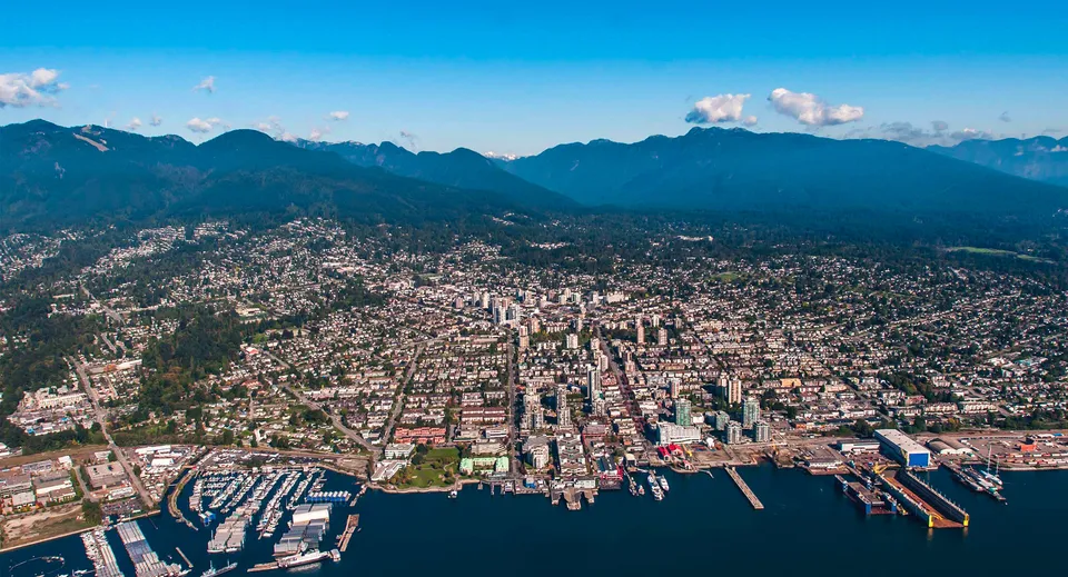 Le aree urbane con porto e grattacieli davanti alle montagne nei dintorni della Sutherland Secondary School.