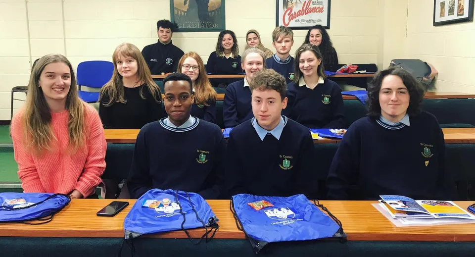 Studenti della St. Tiernan’s Community School siedono in uniforme scolastica ai banchi con il materiale scolastico.