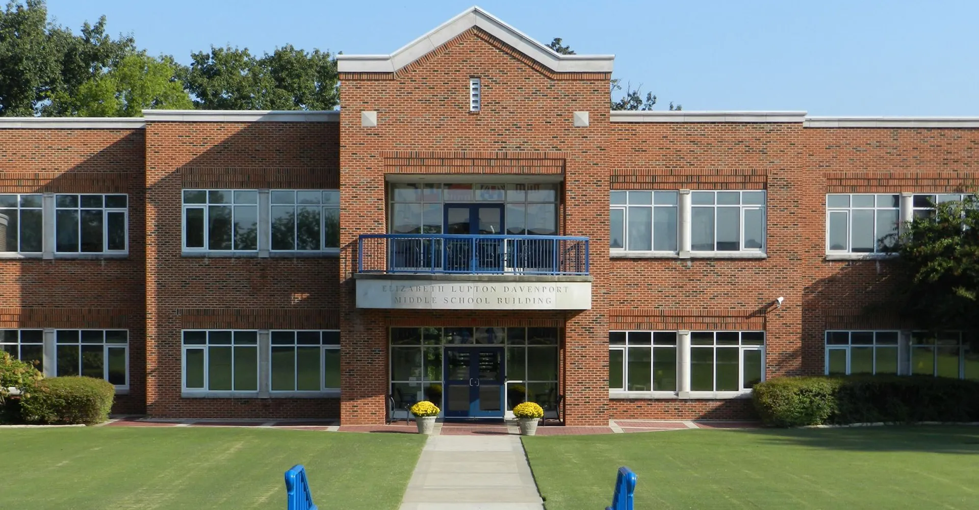 L'edificio in mattoni a più piani della Girls Preparatory School è circondato da alberi e da un prato.
