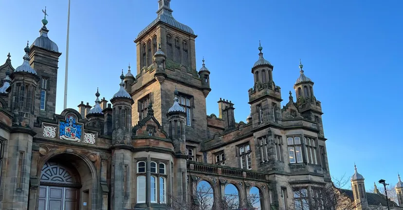L'imponente edificio principale del Stewart’s Melville College con ricchi dettagli architettonici in una giornata limpida.