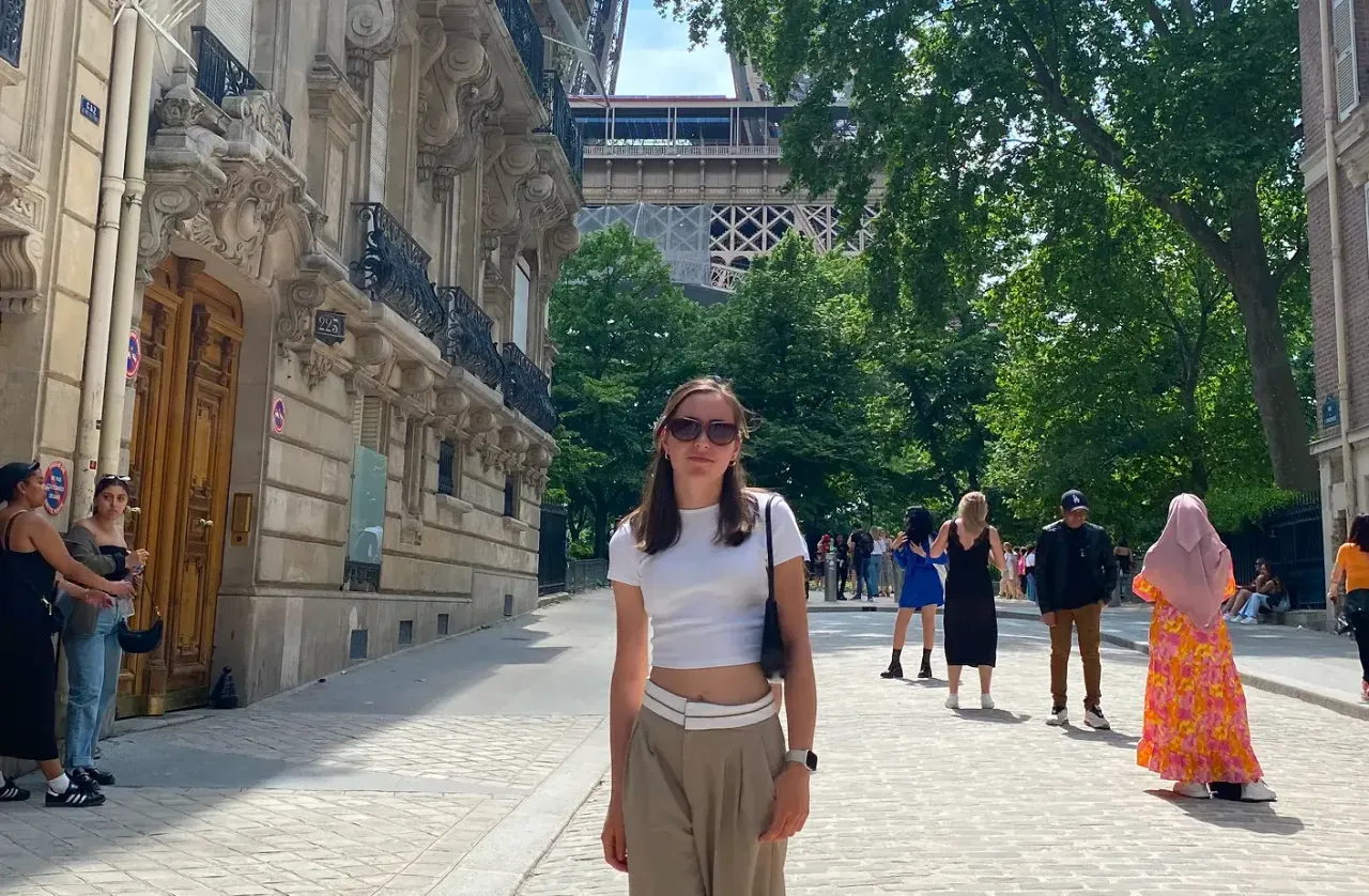 Studentessa in una via di Parigi con la Torre Eiffel sullo sfondo