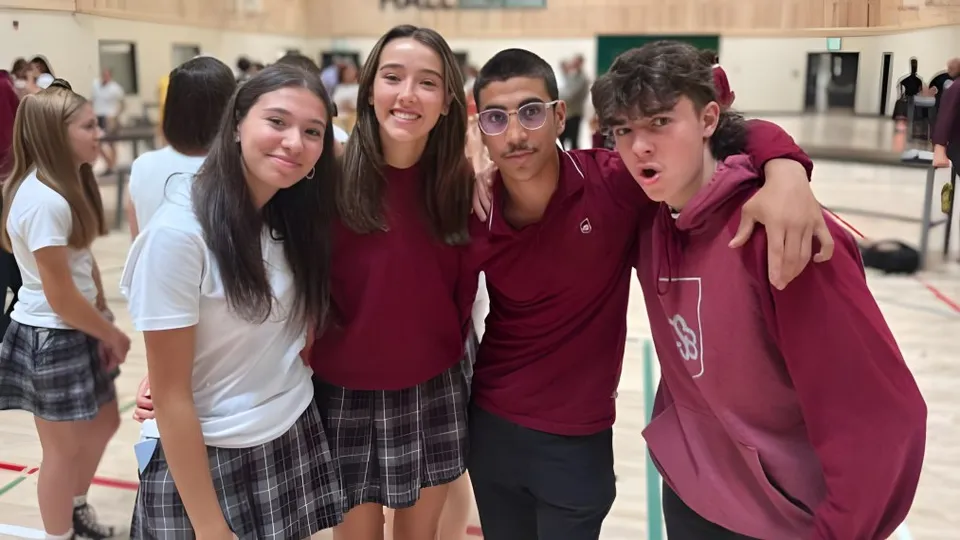 Un gruppo di studenti sorridenti si trova insieme nel corridoio del College Saint-Bernard.