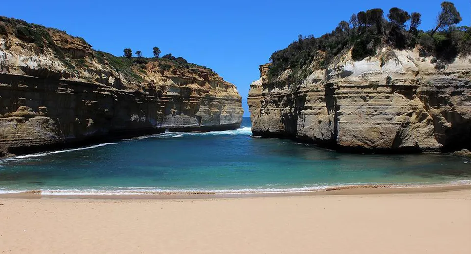 Vista di una tranquilla baia turchese con alte scogliere e spiaggia vicino al Murrumba State Secondary College.