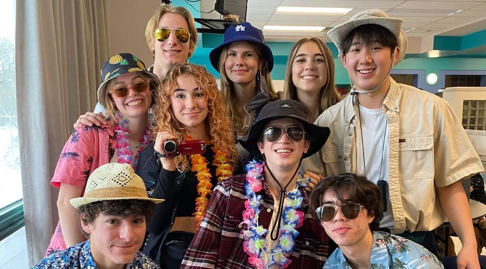 Studenti della St. Mary's High School posano sorridenti con occhiali da sole, cappelli e ghirlande di fiori.