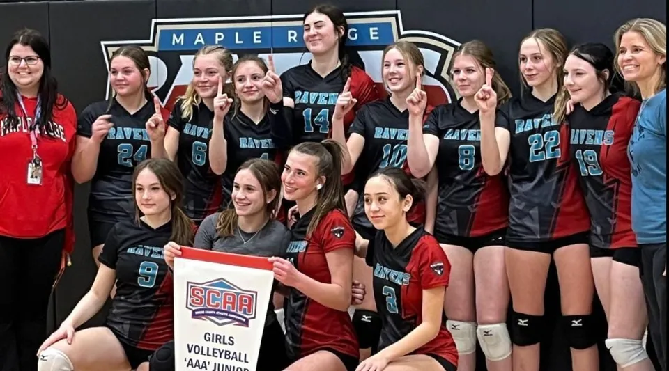Un gruppo di pallavoliste posa insieme davanti alla scritta della Maple Ridge Secondary School in Ontario.