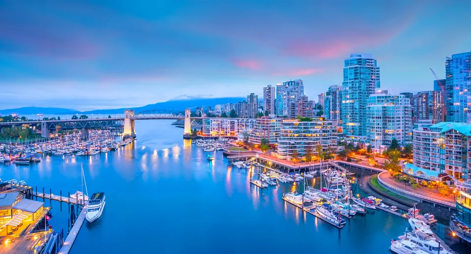 Edifici moderni lungo una baia con porto turistico e un ponte vicino alla Burnaby Central School.