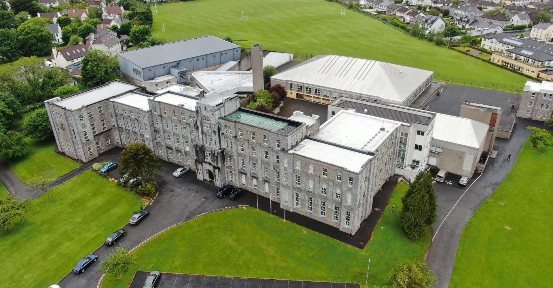 Vista aerea dell'edificio scolastico del Colaiste Muire Mathair circondato da campi sportivi e aree verdi.