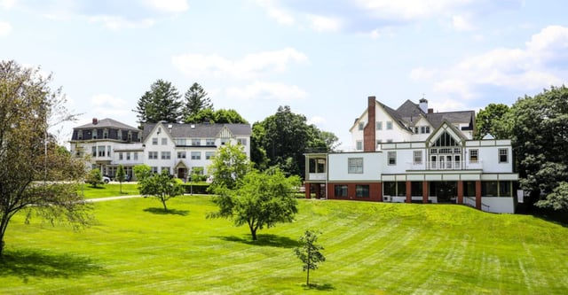 Eine grüne Wiese vor verschiedenen historischen Gebäuden auf dem Campus der Walnut Hill School for the Arts.