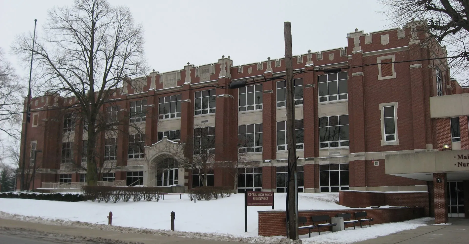 Il grande edificio in mattoni della Kokomo-Center Township Consolidated School Corporation è circondato da un terreno innevato e alberi spogli.