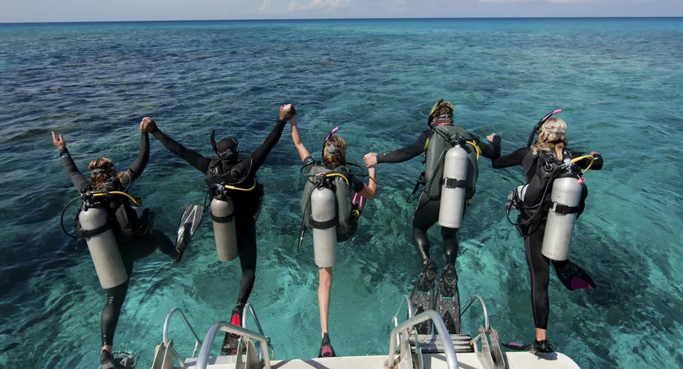 Un gruppo di studenti della Trinity Bay State High School mentre fa immersioni nell'acqua limpida e turchese di un oceano tropicale.