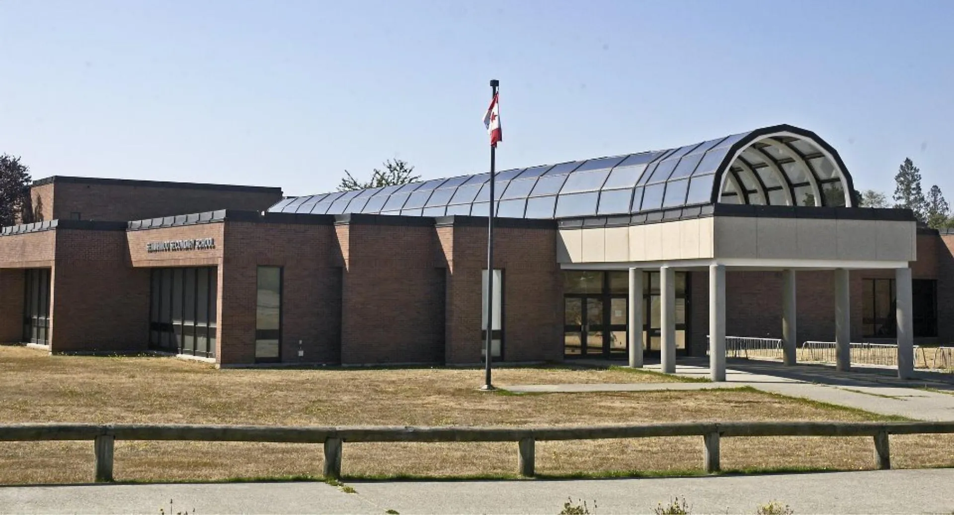 L'edificio in mattoni della Semiahmoo Secondary School con un tetto in vetro ad arco e un pennone con la bandiera.