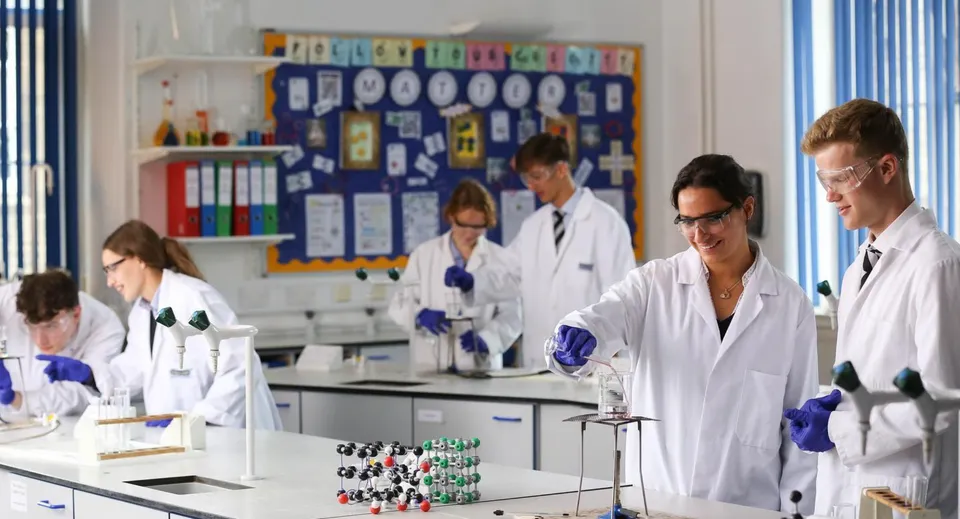 Studenti del Bishopstrow College lavorano in laboratorio con camici bianchi e strumenti scientifici.