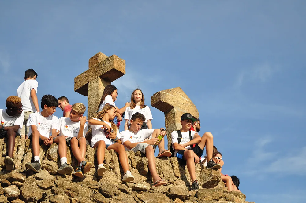 Jugendliche des Camps sitzen beim Ausflug auf einer Felsformation