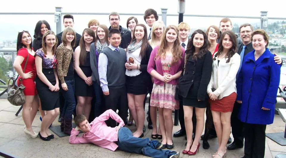 Un gruppo di studentesse della John Maland High School all'aperto davanti a un paesaggio urbano.